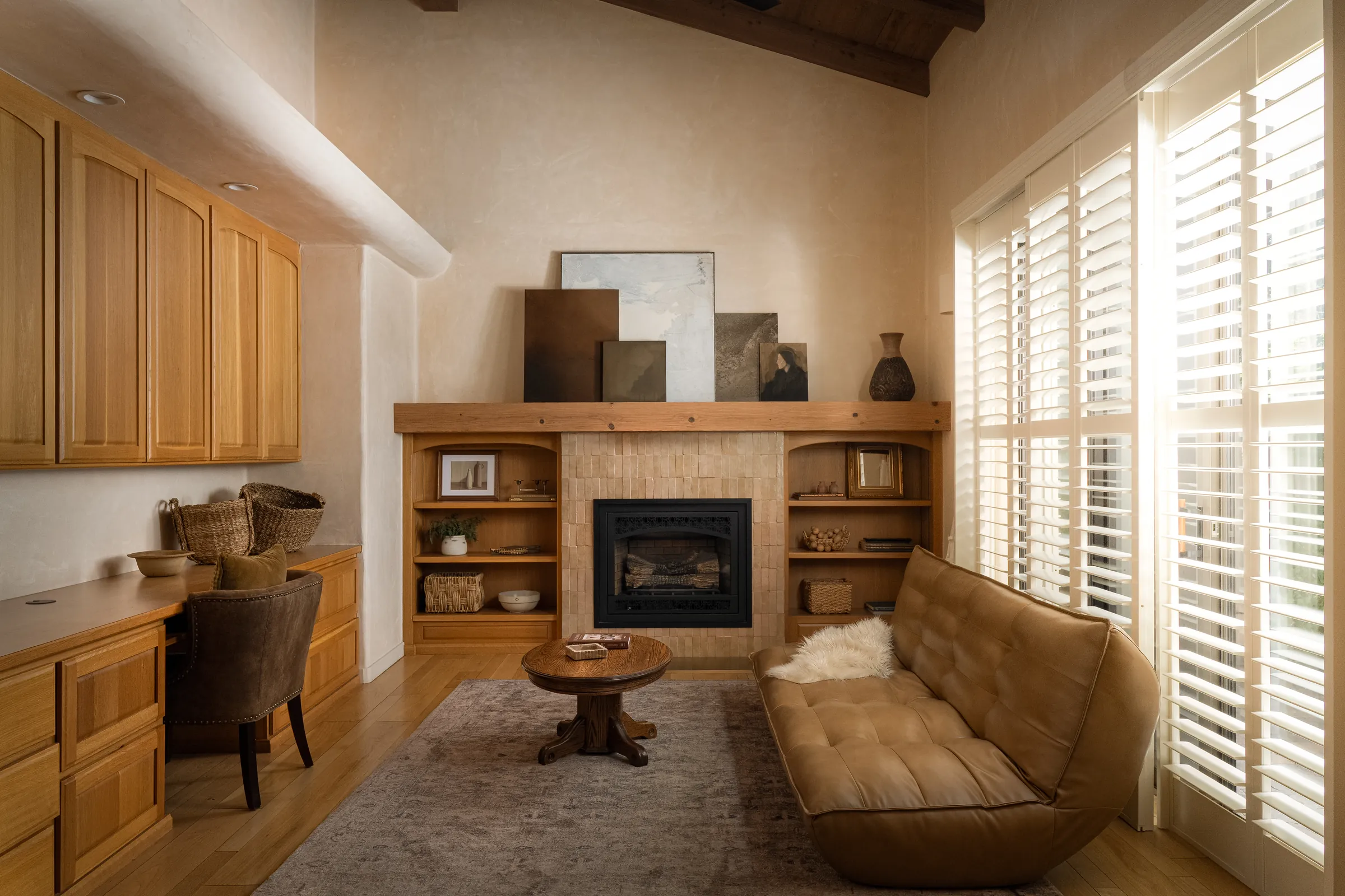 A single-story house behind clipped hedges, with an olive tree, a gravel court and a deep colonnade. Frame 8 of 25.