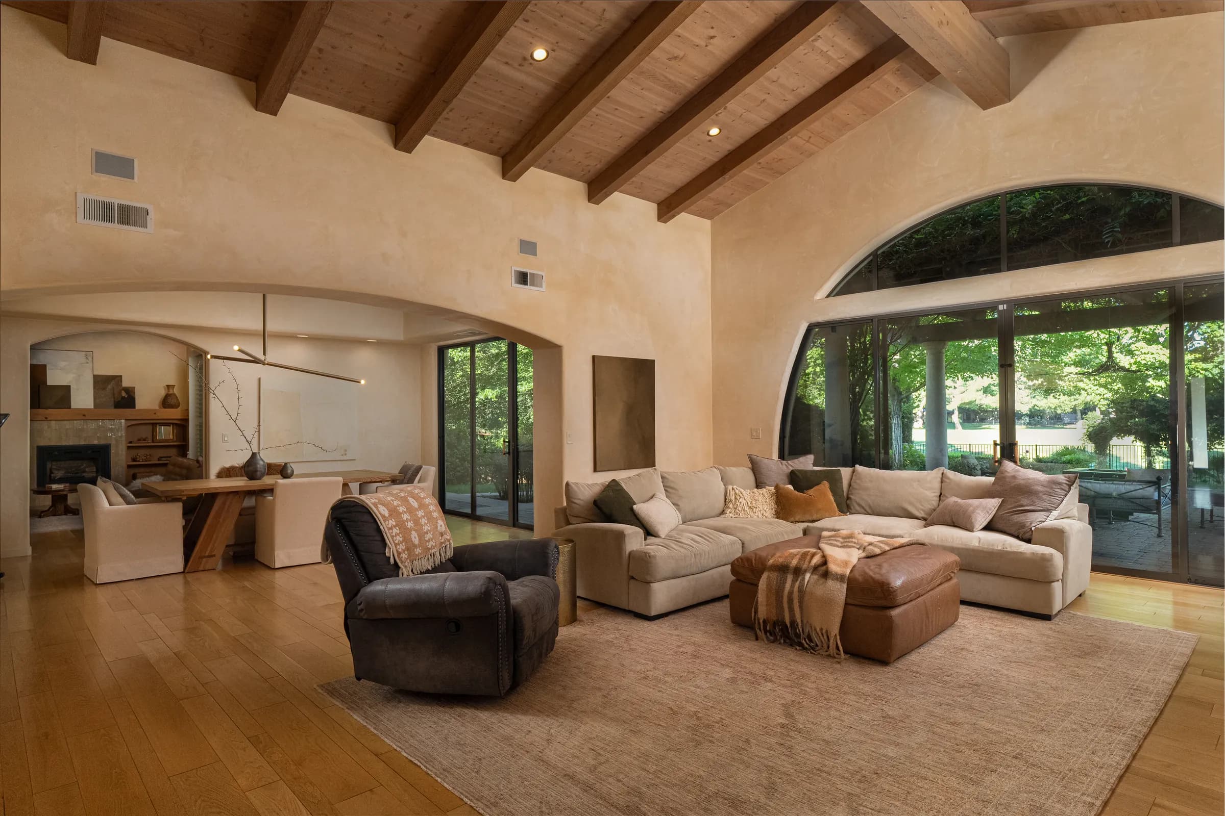 A single-story house behind clipped hedges, with an olive tree, a gravel court and a deep colonnade. Frame 10 of 25.