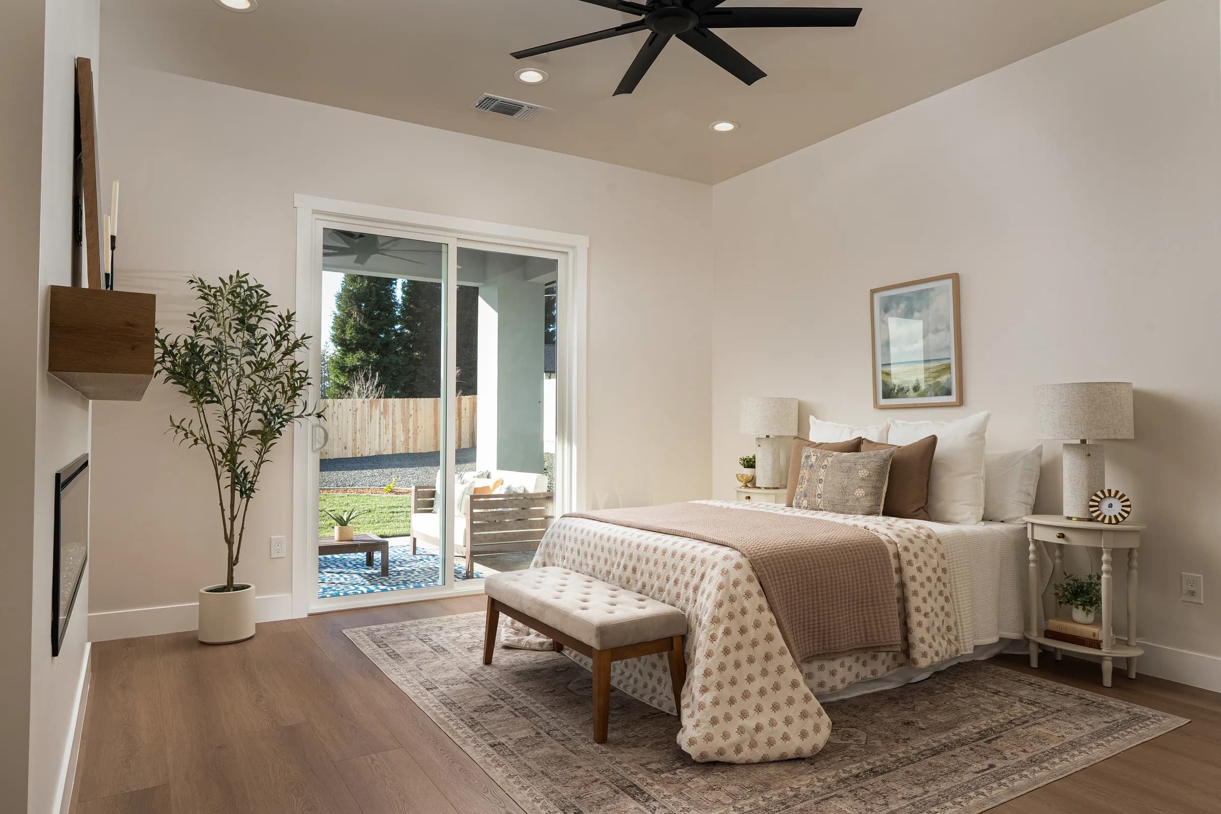 A contemporary house behind a black slatted fence with mature palms, and its interiors: a pale living room, an open kitchen and a detail of a patterned rug against leather. Frame 8 of 23.