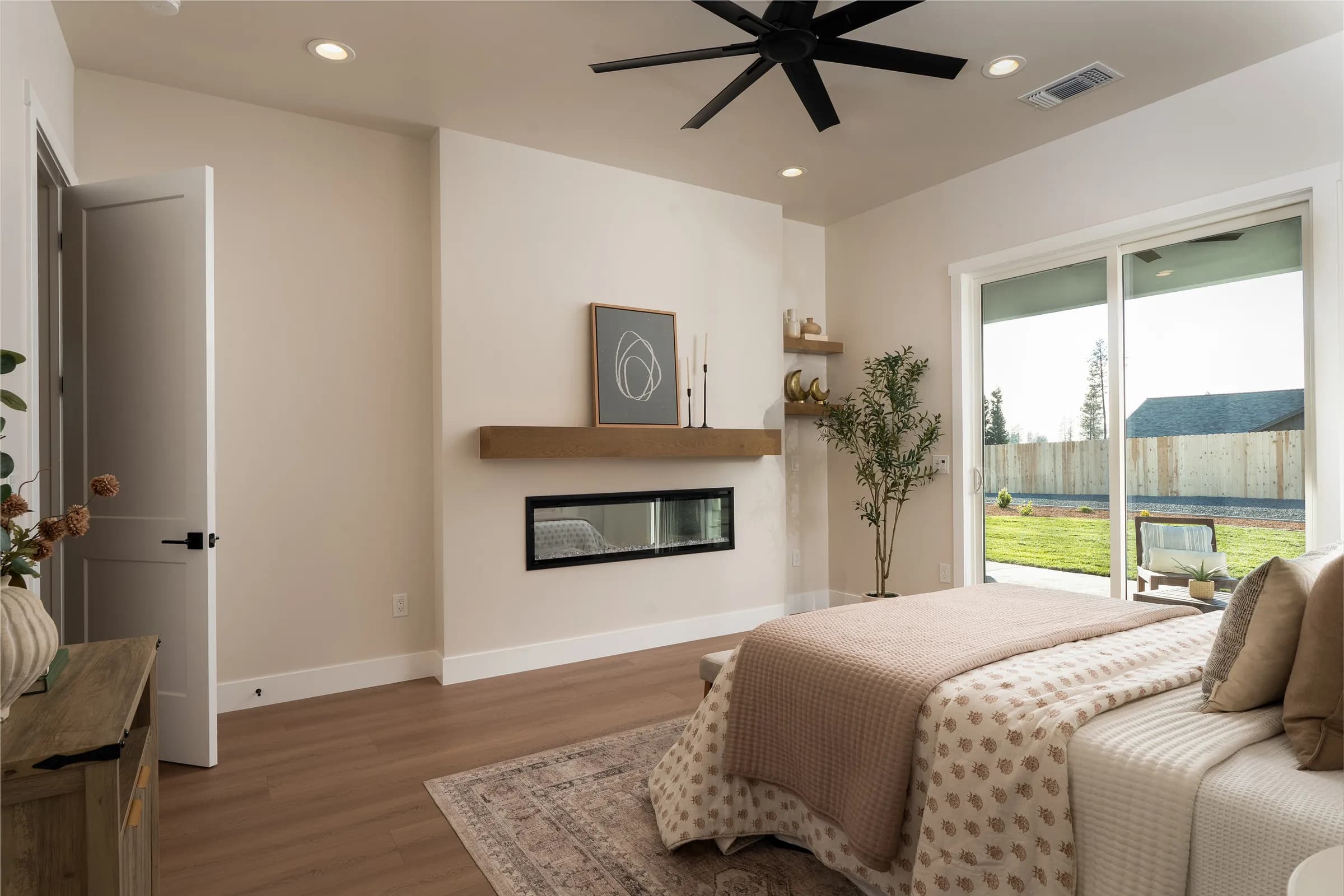 A contemporary house behind a black slatted fence with mature palms, and its interiors: a pale living room, an open kitchen and a detail of a patterned rug against leather. Frame 9 of 23.